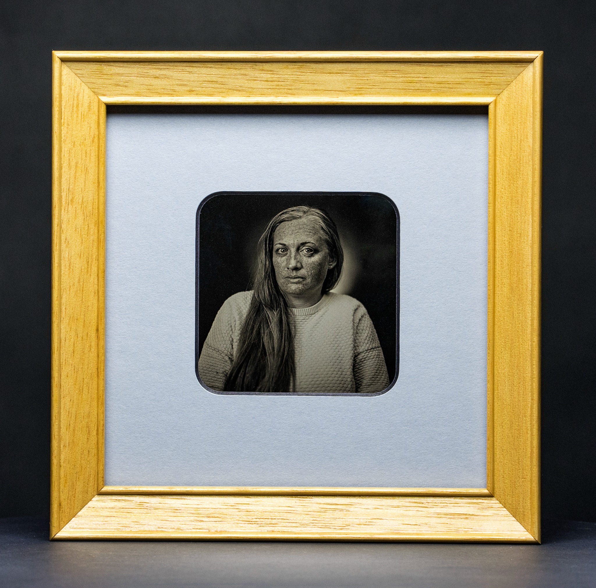 Gerahmte Daguerreotypie: Porträt mit langem Haar und direktem Blick.