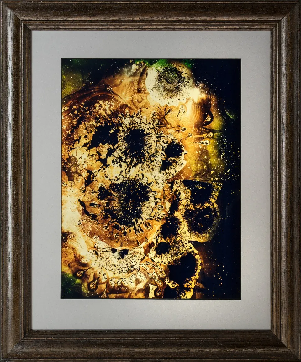Gerahmtes abstraktes Bild mit goldenen ringförmigen Strukturen auf dunkelblauem Grund.