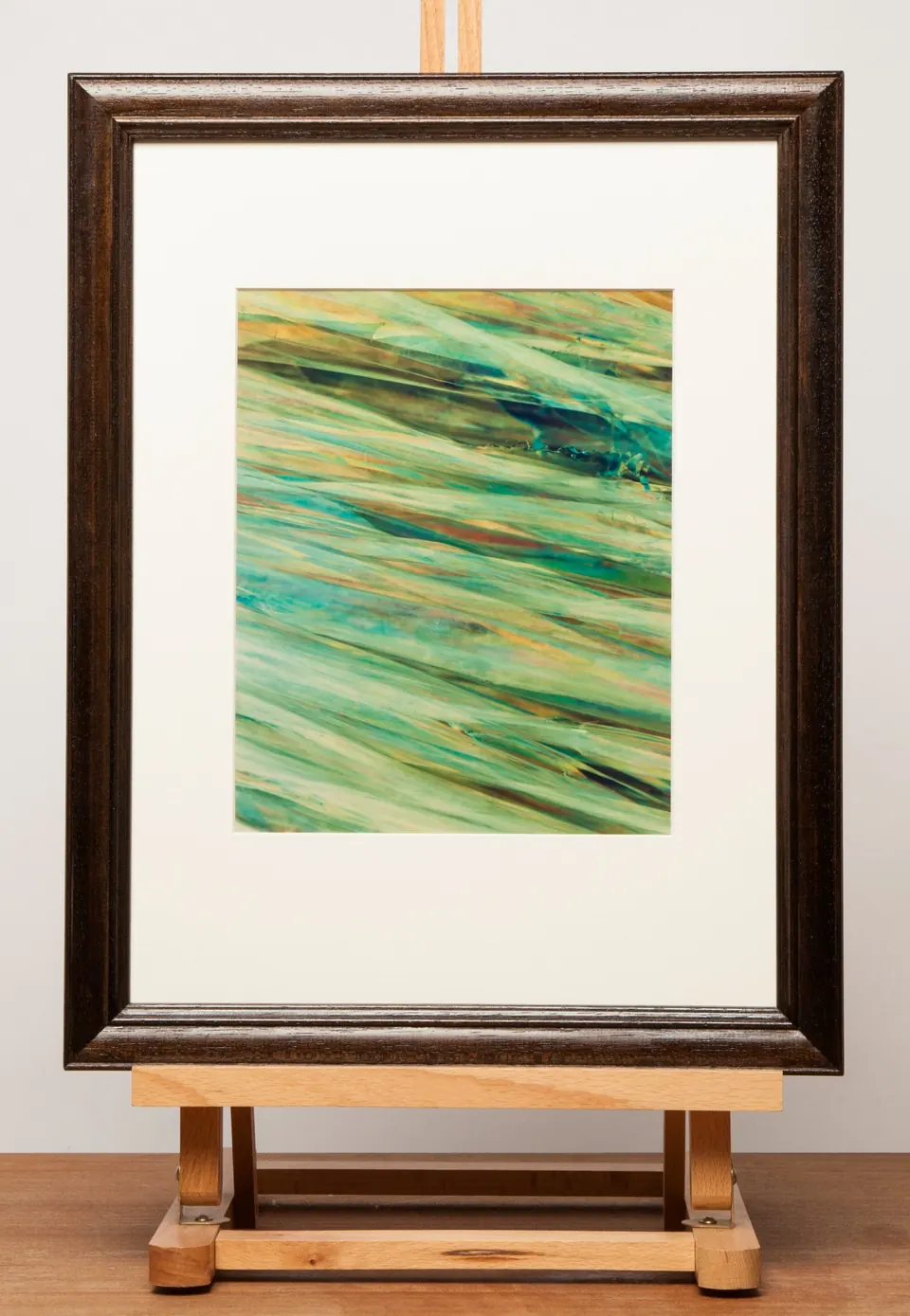 Gerahmtes abstraktes Bild mit hellgrünen und blauen diagonalen Linien.