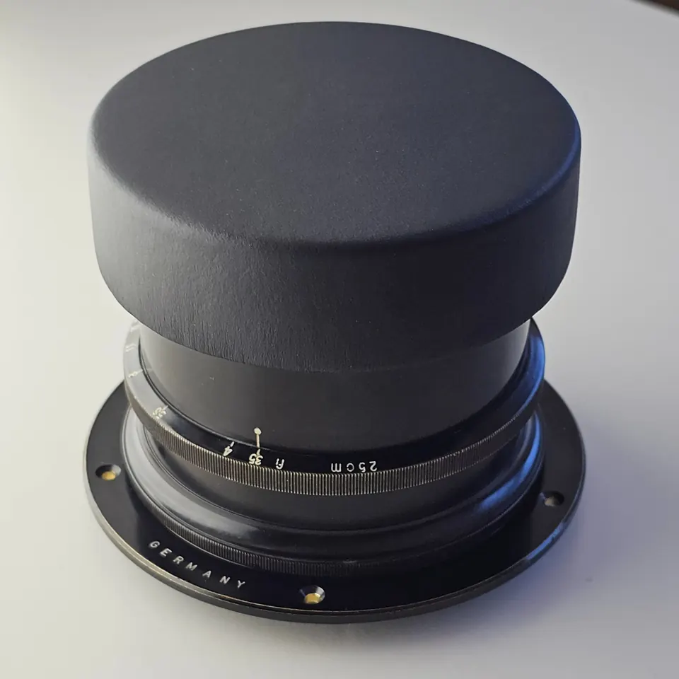 Tessar 25 cm f/3,5 mit aufgesetztem schwarzem Lederdeckel.