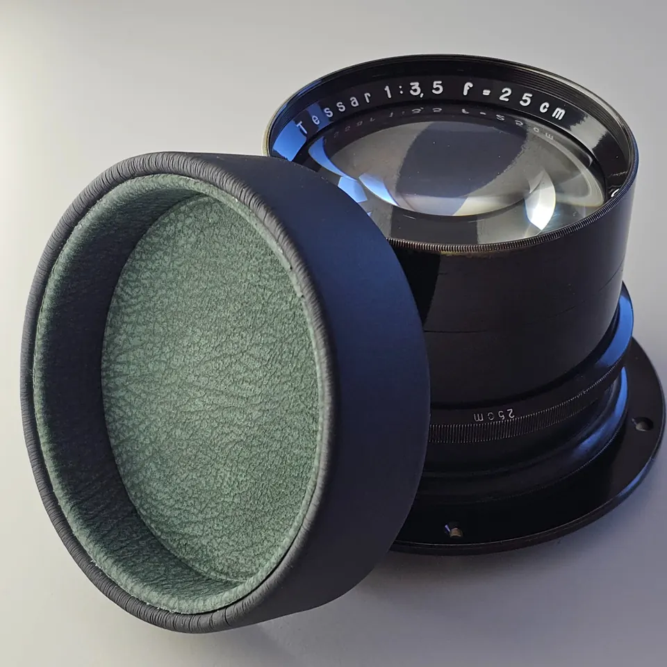 Tessar 25 cm f/3,5 neben dem Lederdeckel mit grüner Rauleder-Innenauskleidung.